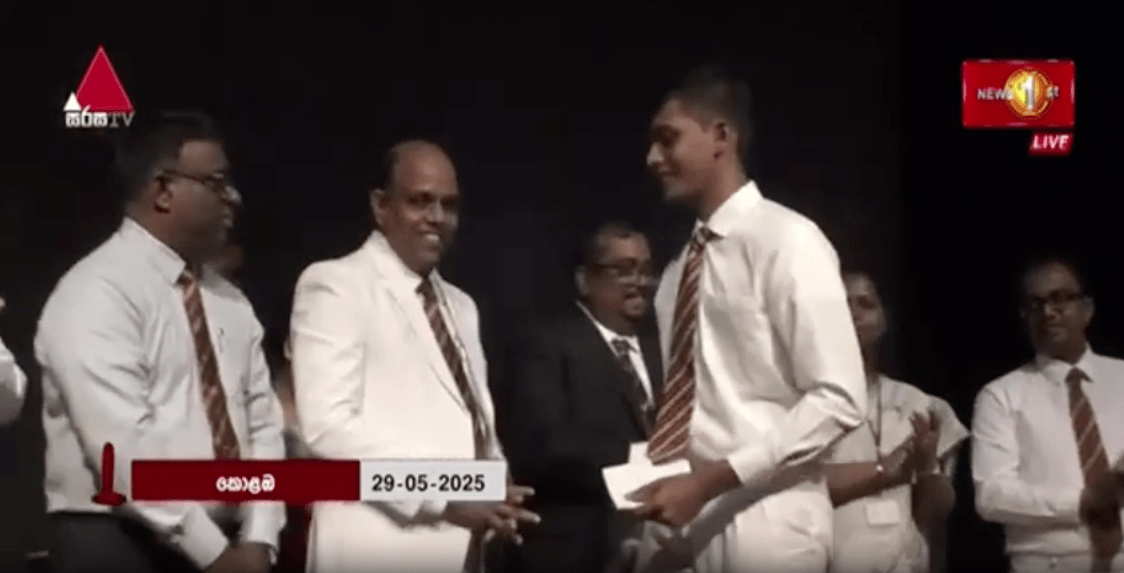 Blind student on the stage with the principle and other guests